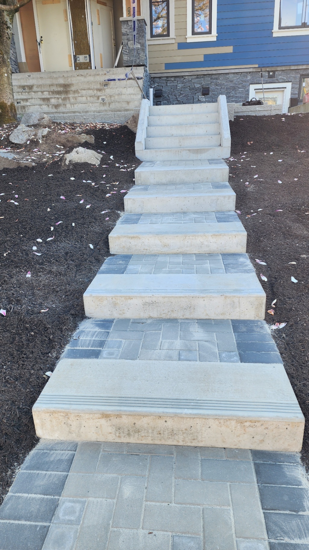 Custom concrete and paver staircase leading up to a new home
