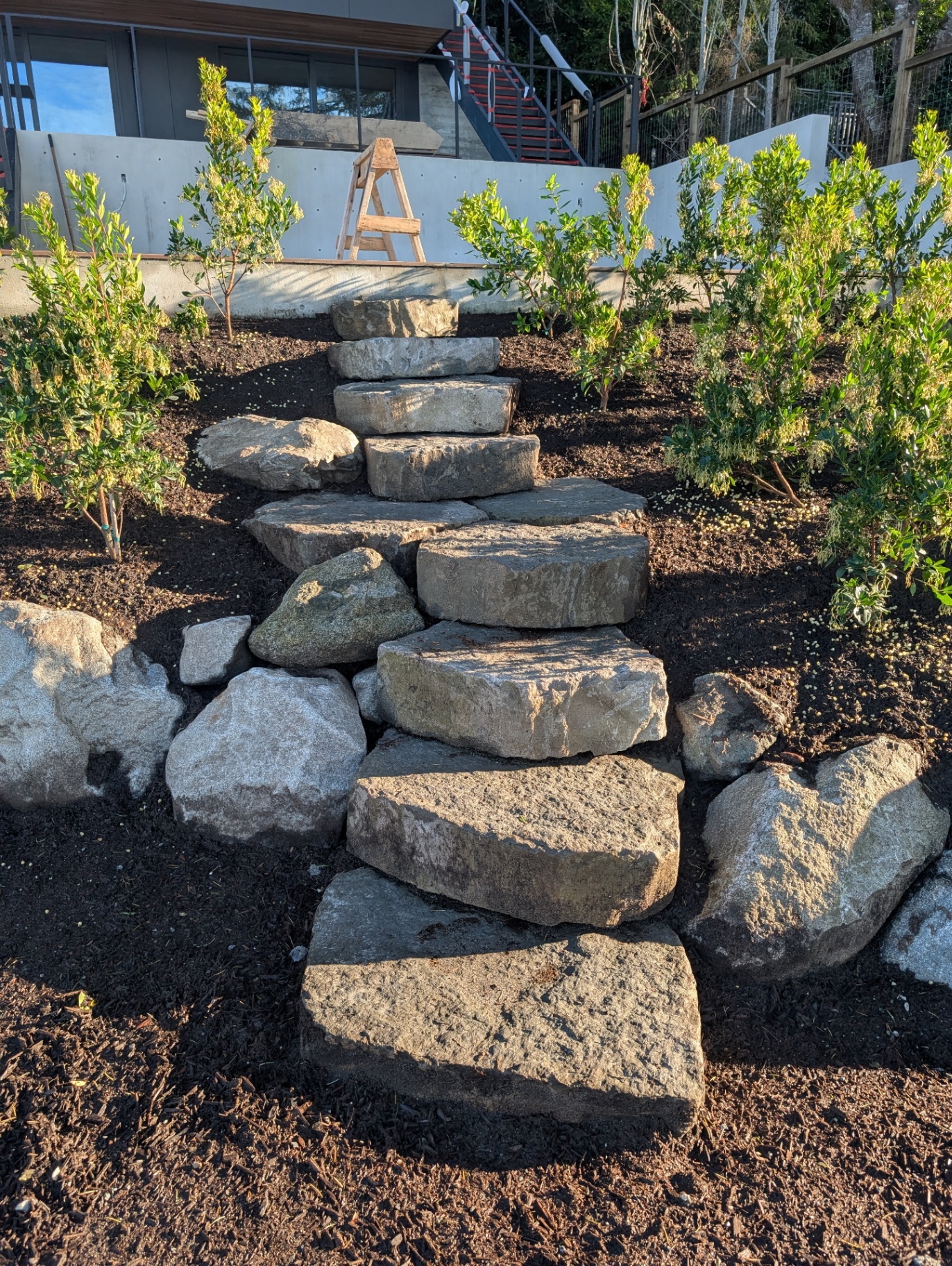 Natural stone boulder steps set into a planted hillside